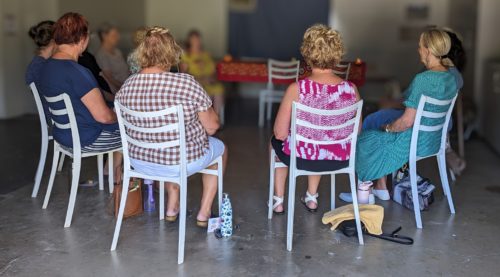 People sitting in chairs at meditation session