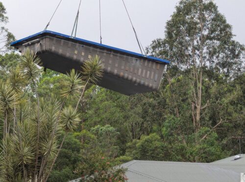 Pool being craned in over a house roof