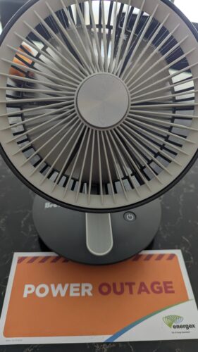 Desktop fan and flyer saying power outage